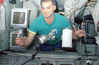 Mir-24 crewmember David Wolf demonstrates weightlessness with various items on the Base Block of the Mir Space Station during NASA-6. 